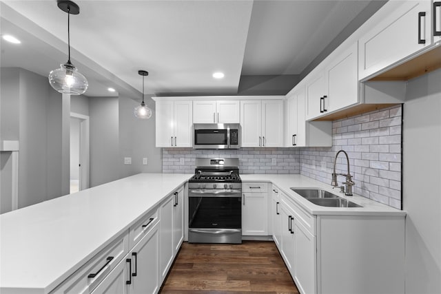 kitchen with dark wood-type flooring, sink, white cabinets, pendant lighting, and appliances with stainless steel finishes