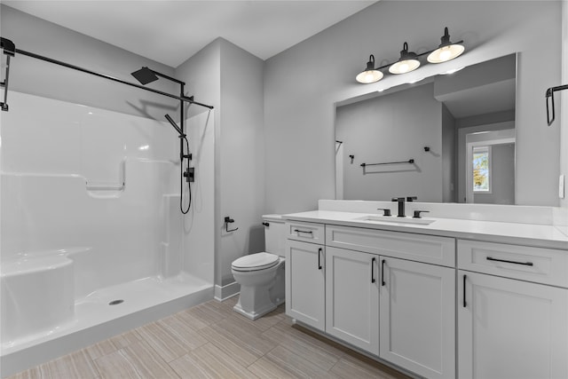 bathroom with toilet, vanity, and a shower