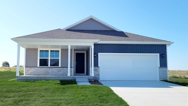 view of front of home with a front yard, a garage, and covered porch