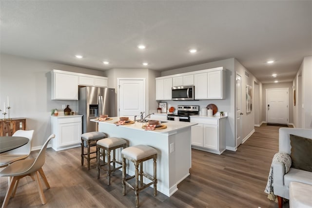 kitchen featuring sink, white cabinetry, appliances with stainless steel finishes, and a kitchen island with sink