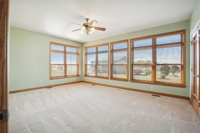 carpeted spare room with ceiling fan