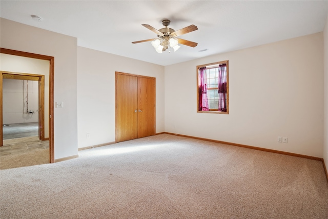 unfurnished bedroom with a closet, ceiling fan, and light carpet