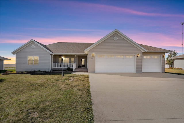 single story home featuring covered porch, a garage, and a lawn