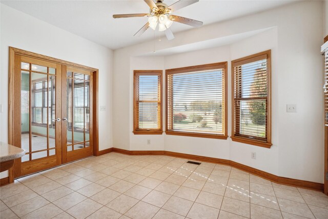 spare room with french doors, ceiling fan, and light tile patterned floors