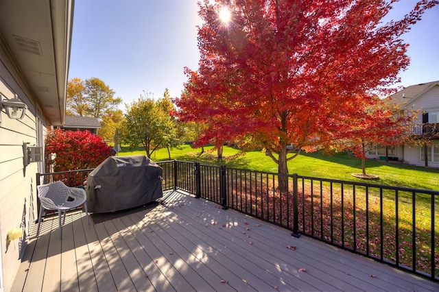 deck with grilling area and a yard