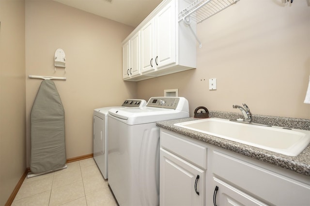 washroom with cabinet space, light tile patterned floors, baseboards, separate washer and dryer, and a sink