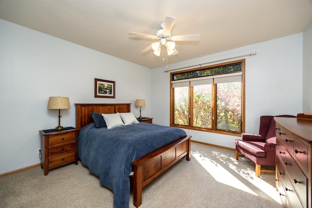 bedroom featuring light colored carpet, ceiling fan, and baseboards