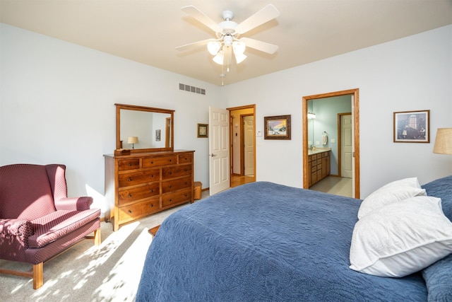 bedroom with a ceiling fan, visible vents, connected bathroom, and light carpet