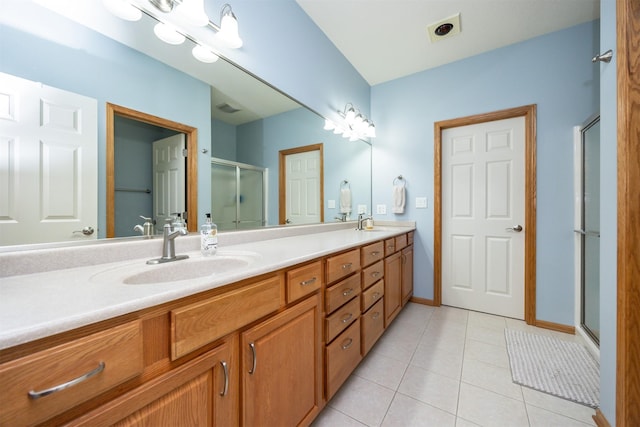 full bath with double vanity, visible vents, a sink, a shower stall, and tile patterned floors