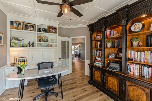 office featuring light hardwood / wood-style floors, coffered ceiling, ornamental molding, and ceiling fan with notable chandelier