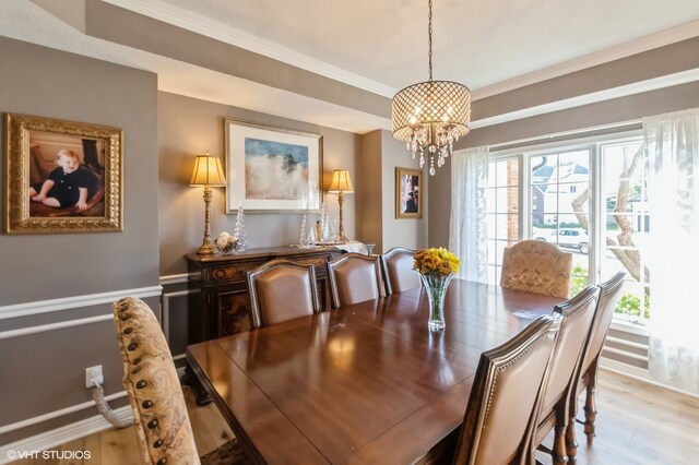 dining area featuring a chandelier, crown molding, and light wood-type flooring