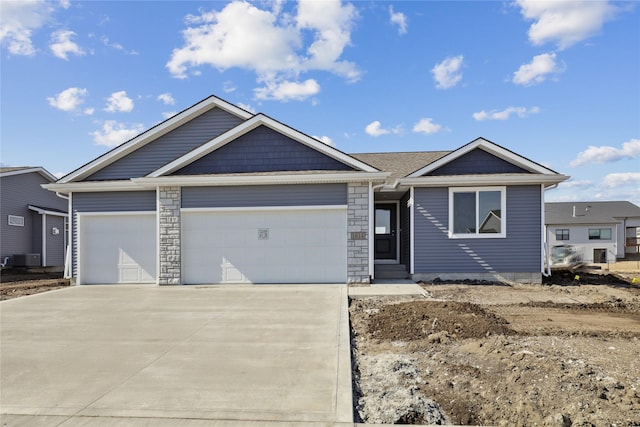 ranch-style house featuring a garage, concrete driveway, and stone siding