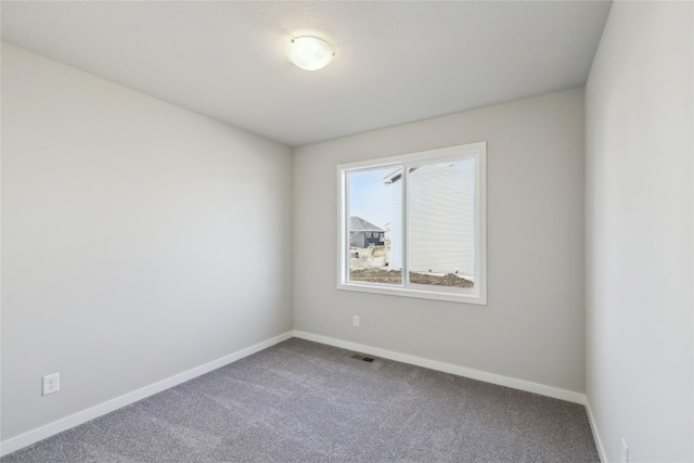 unfurnished room featuring carpet floors, visible vents, and baseboards