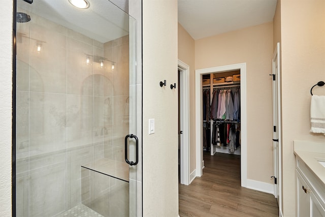 bathroom with vanity, wood-type flooring, and walk in shower