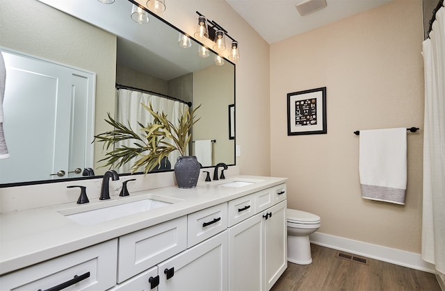 bathroom featuring vanity, toilet, and wood-type flooring