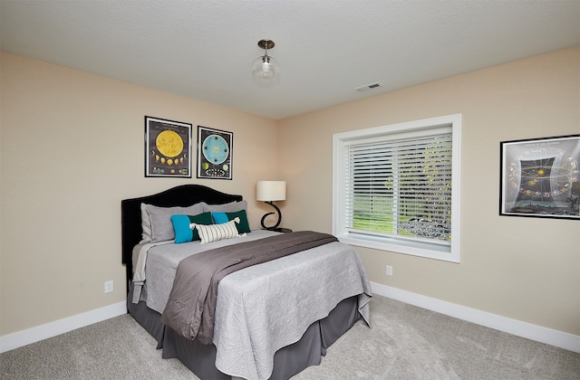 bedroom featuring light carpet and a textured ceiling