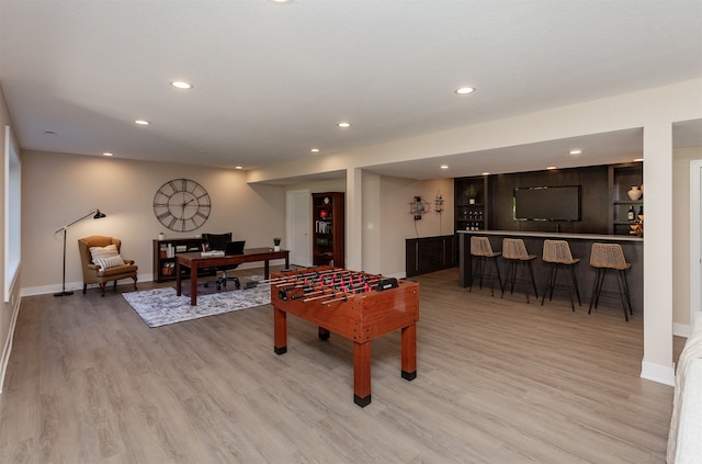 rec room featuring bar area and light hardwood / wood-style floors