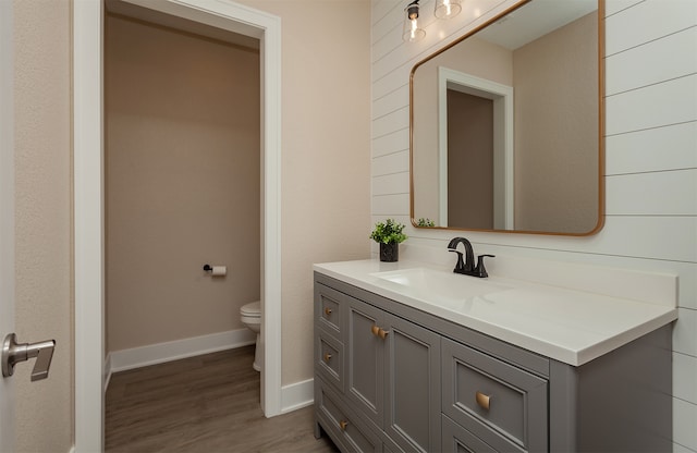 bathroom with vanity, toilet, and hardwood / wood-style flooring