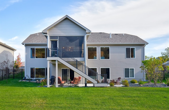 back of property featuring a yard, a patio, and a sunroom