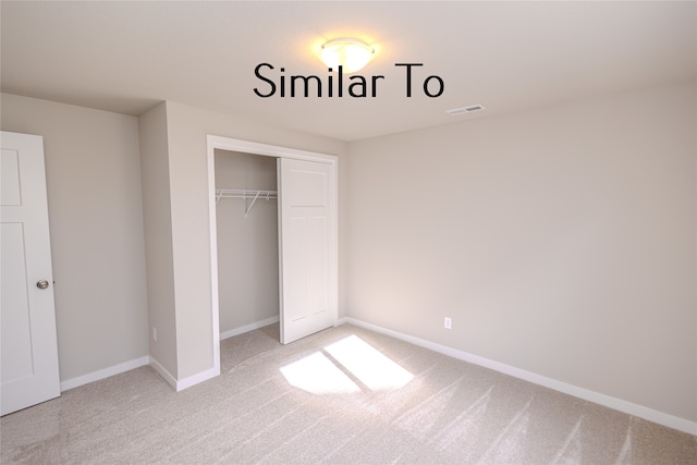 unfurnished bedroom featuring a closet and light colored carpet