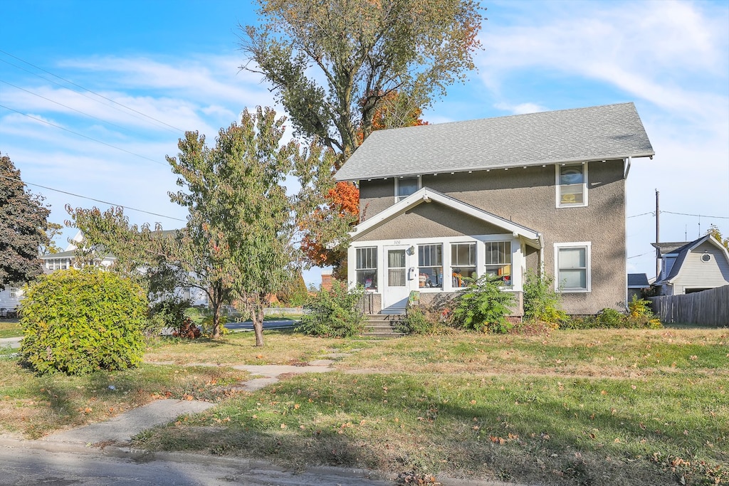 exterior space featuring a front yard and a sunroom