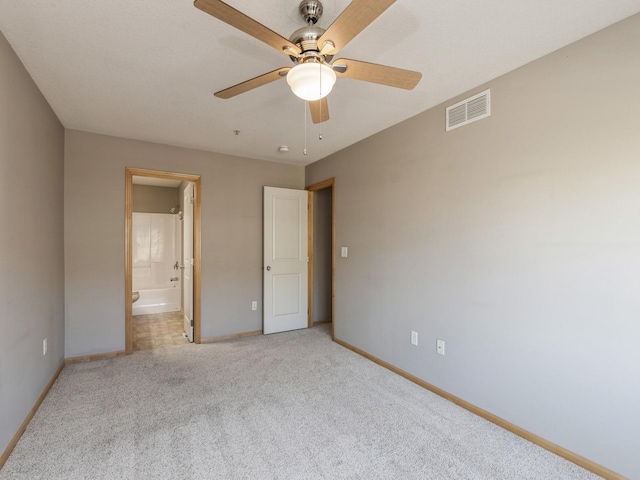 unfurnished bedroom with ceiling fan, ensuite bathroom, and light carpet