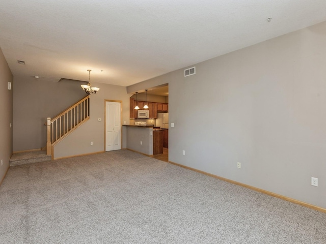 unfurnished living room with light carpet and an inviting chandelier