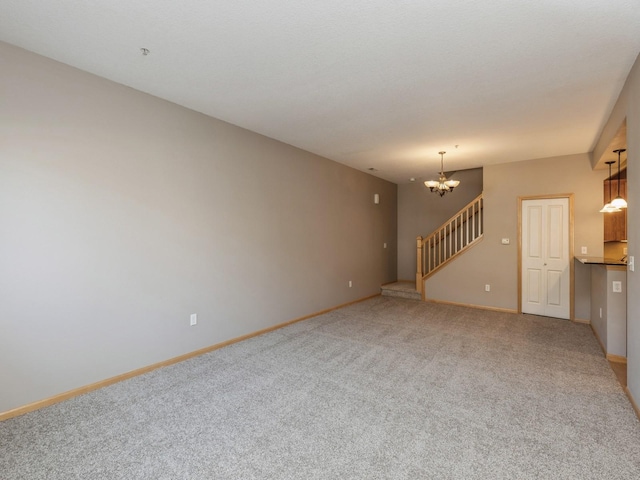 unfurnished living room with carpet flooring and a notable chandelier