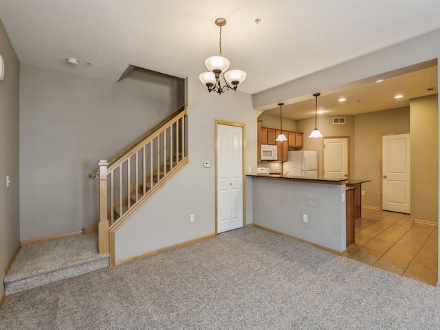 kitchen featuring kitchen peninsula, a chandelier, light colored carpet, pendant lighting, and white appliances