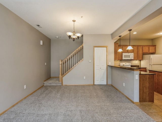 kitchen featuring kitchen peninsula, light carpet, white appliances, pendant lighting, and an inviting chandelier