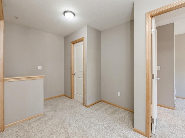 interior space with a textured ceiling and light carpet