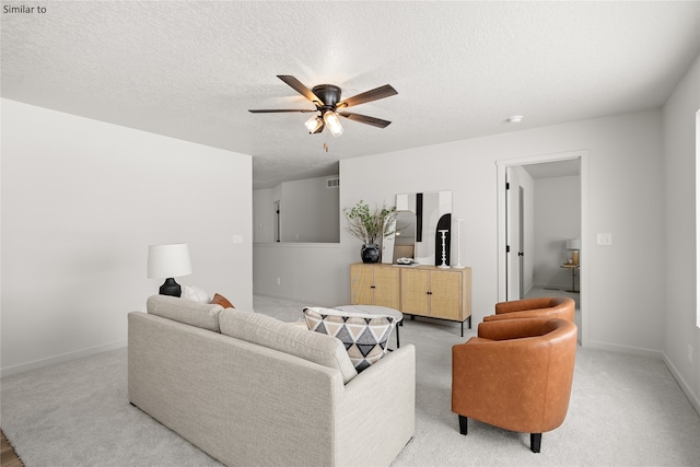 living room featuring a textured ceiling, light colored carpet, and ceiling fan