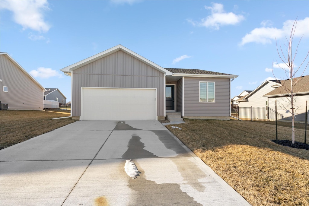 view of front facade with a front yard, a garage, and cooling unit