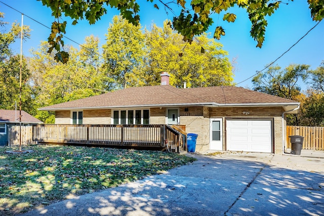 ranch-style house with a garage and a wooden deck