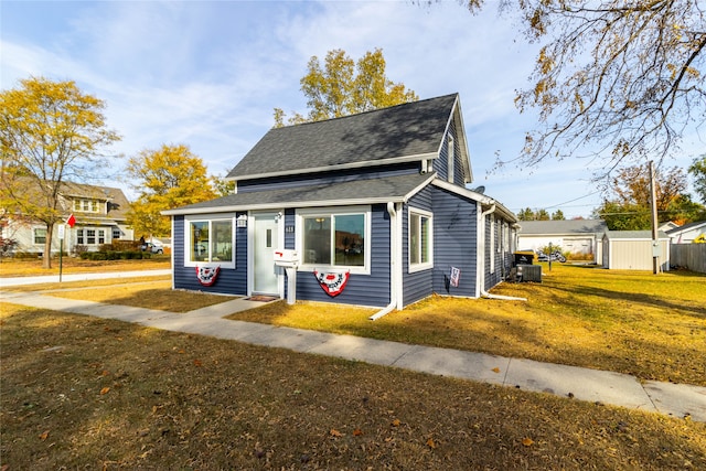 view of front of property with central AC and a front lawn