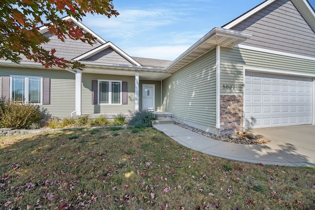 view of front of home featuring a garage, concrete driveway, a front lawn, and stone siding