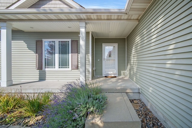 view of exterior entry featuring covered porch