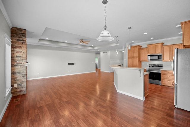 kitchen featuring light countertops, pendant lighting, appliances with stainless steel finishes, open floor plan, and an island with sink