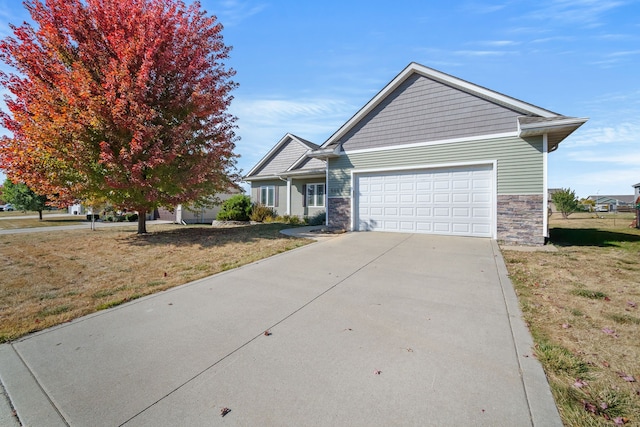 view of front of property featuring concrete driveway, an attached garage, stone siding, and a front lawn