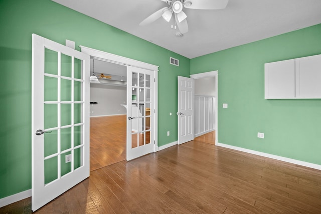 unfurnished room featuring wood finished floors, french doors, a ceiling fan, and visible vents