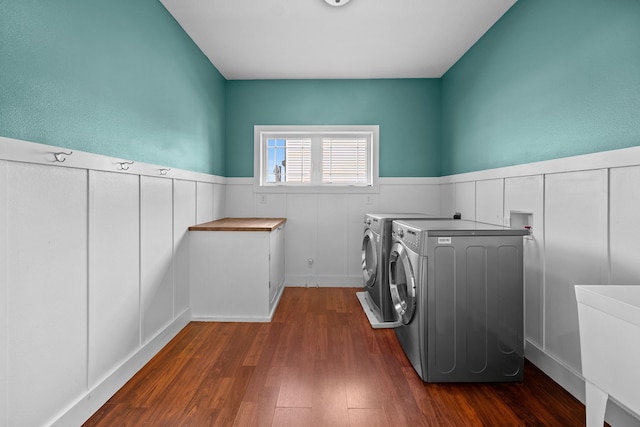 washroom with separate washer and dryer, cabinet space, wainscoting, and dark wood-style floors