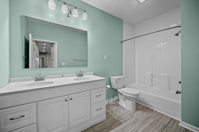 bathroom featuring double vanity, toilet, wood tiled floor, and a sink