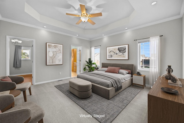 bedroom featuring multiple windows, a raised ceiling, and light carpet