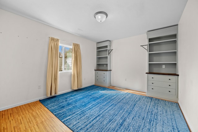 unfurnished bedroom with wood finished floors and baseboards