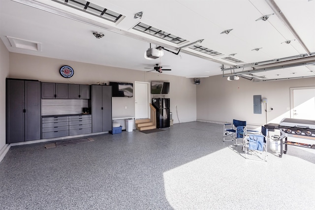 garage with a garage door opener, electric panel, and ceiling fan