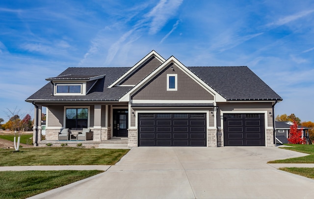 craftsman house with a porch, a front lawn, and a garage