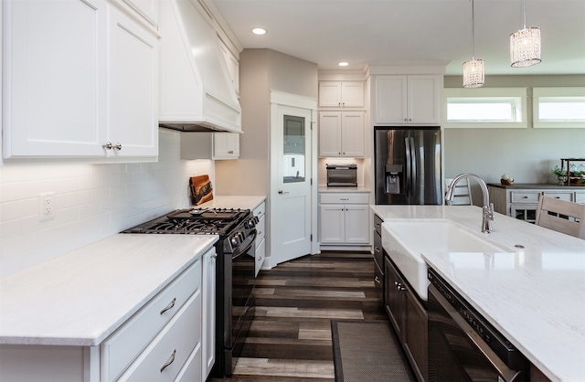 kitchen with black appliances, white cabinetry, decorative light fixtures, dark wood-type flooring, and premium range hood