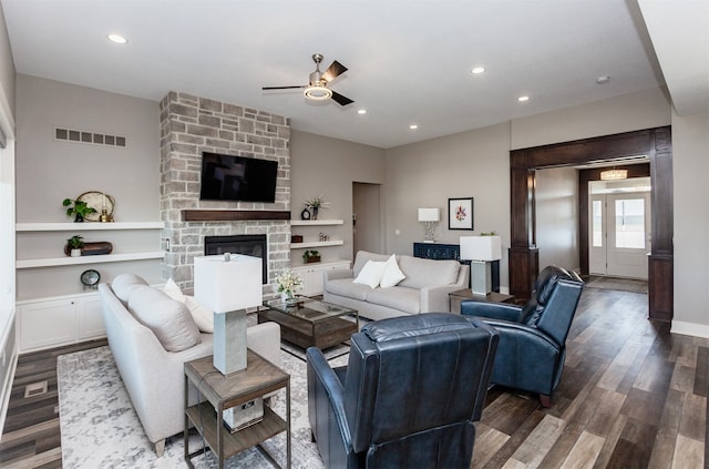 living room with hardwood / wood-style floors, a stone fireplace, and ceiling fan