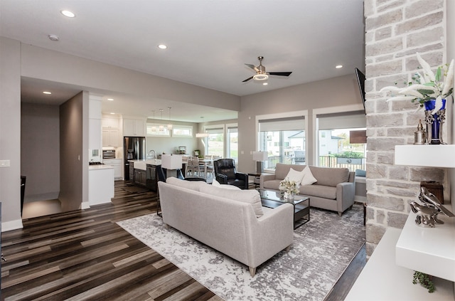 living room with sink, dark wood-type flooring, and ceiling fan