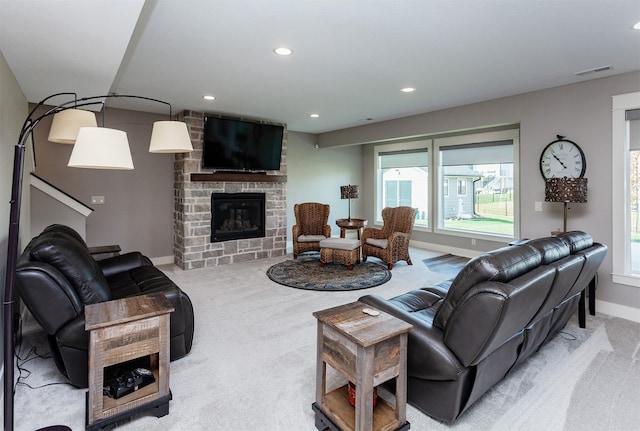 living room with a stone fireplace and light colored carpet